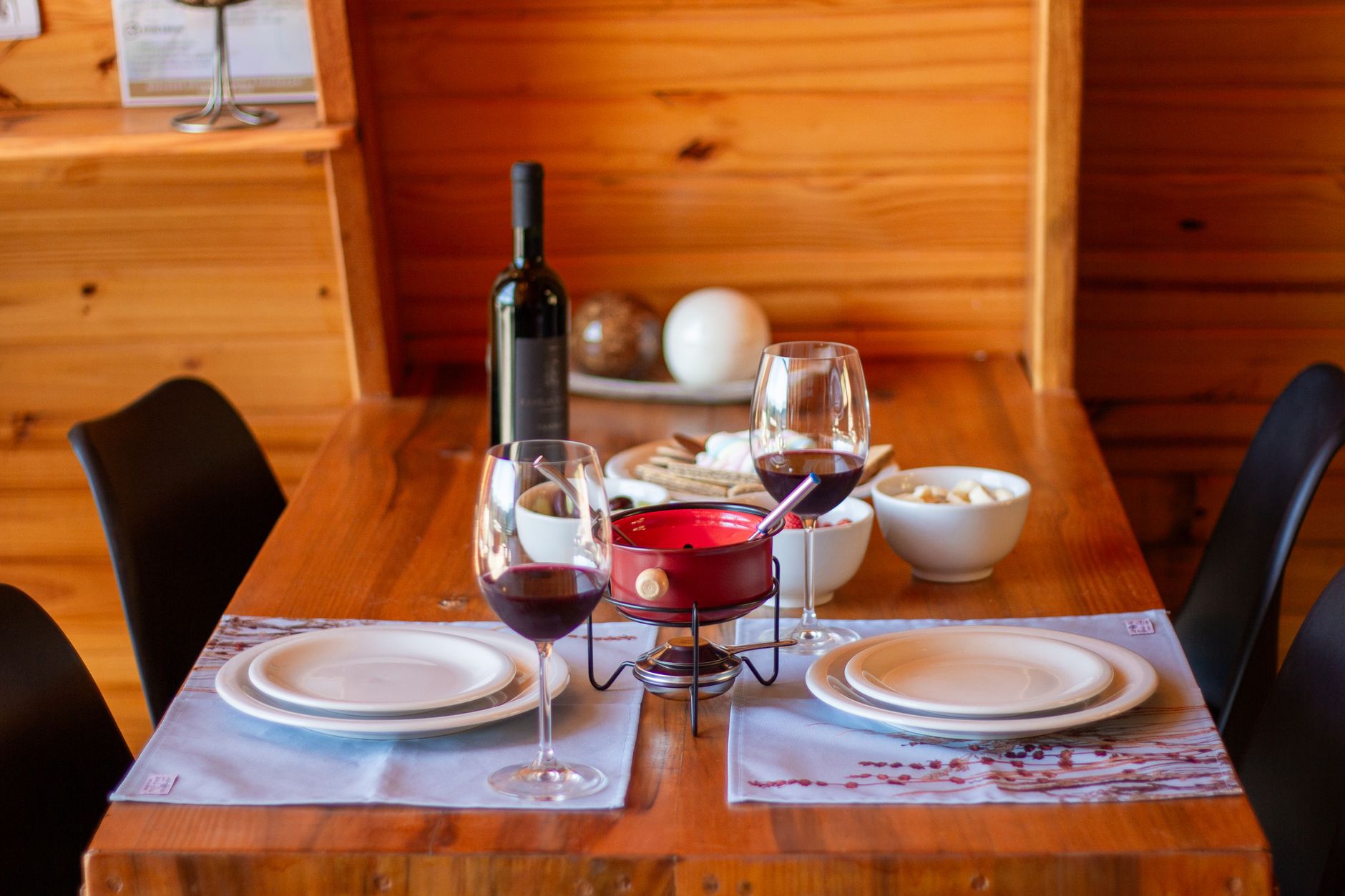 Table dressée au Café du Soleil avec fondue, vin rouge et pain maison